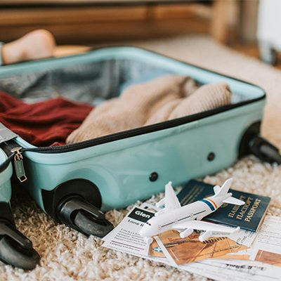 geöffneter Koffer mit Kleidung und Reiseutensilien auf einer Tasche