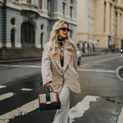 Blog für Damen Kategoriebild, Frau in hellem Mantel und weißer Hose auf der Straße